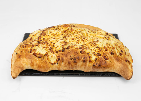 Jonaldo’s large, cheesy, baked calzone on a black serving platter in Kirkcaldy.